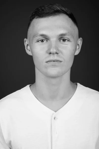 Junger Mann mit weißem Hemd vor grauem Hintergrund — Stockfoto