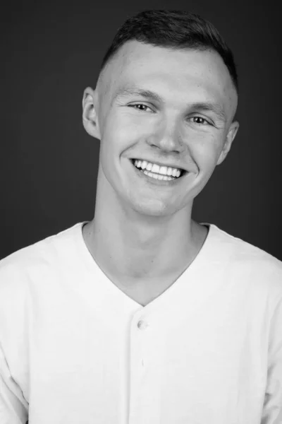 Fiatal férfi fehér inget visel szürke háttér — Stock Fotó