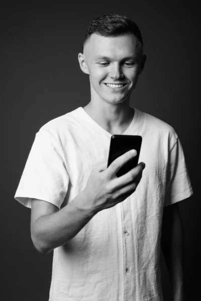 Hombre joven con camisa blanca sobre fondo gris — Foto de Stock