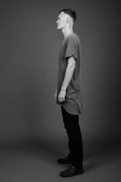 Giovane uomo che indossa camicia grigia contro sfondo grigio — Foto Stock
