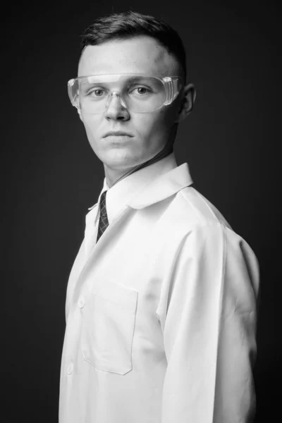 회색 배경에 보호안경을 쓰고 있는 젊은 의사 — 스톡 사진