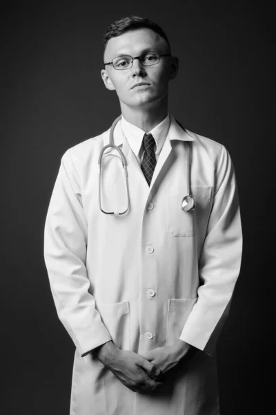 Jonge man arts met bril tegen grijze achtergrond — Stockfoto
