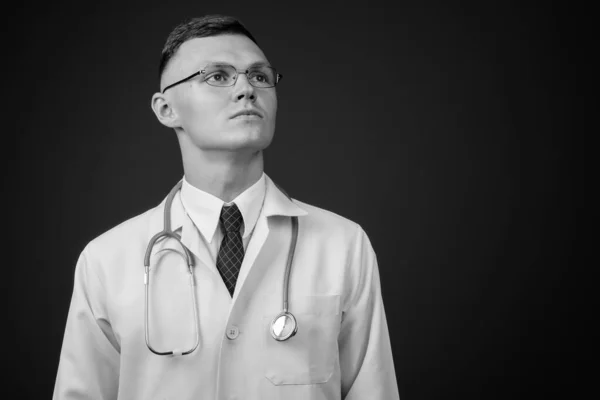 Young man doctor wearing eyeglasses against gray background — Stock Photo, Image