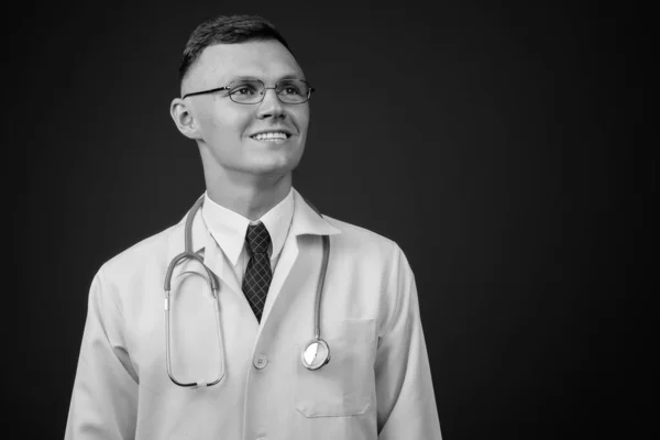 หมอหนุ่มสวมแว่นตากับพื้นหลังสีเทา — ภาพถ่ายสต็อก