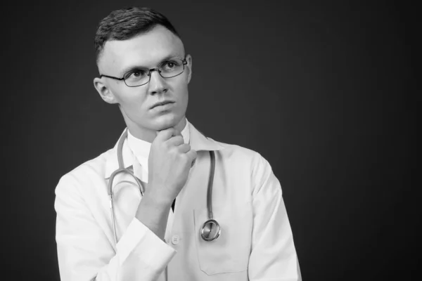 Junger Mann mit Brille vor grauem Hintergrund — Stockfoto