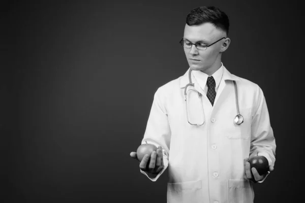 Jeune homme médecin portant des lunettes sur fond gris — Photo