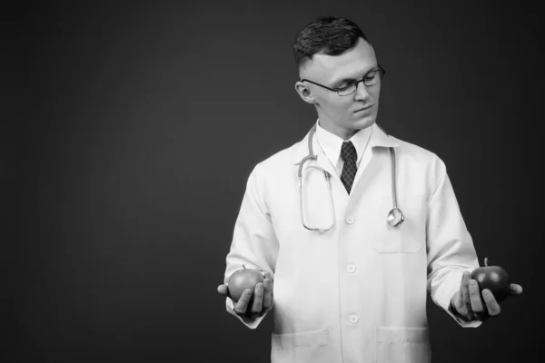 Молодой врач в очках на сером фоне — стоковое фото