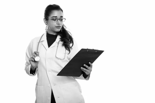 Estudio de la joven hermosa mujer india médico leyendo en el portapapeles —  Fotos de Stock