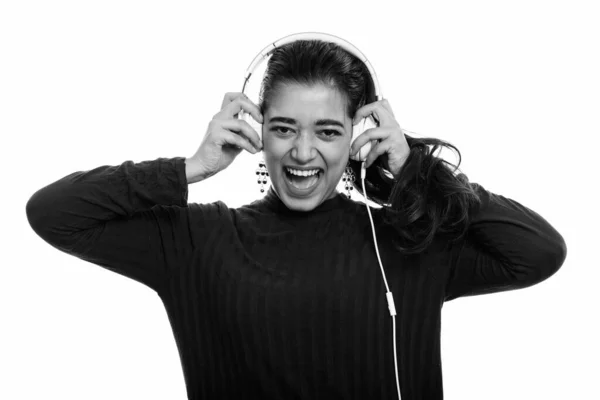 Fiatal boldog indiai nő mosolyog és kiabál, miközben zenét hallgat és fülhallgatót tart — Stock Fotó