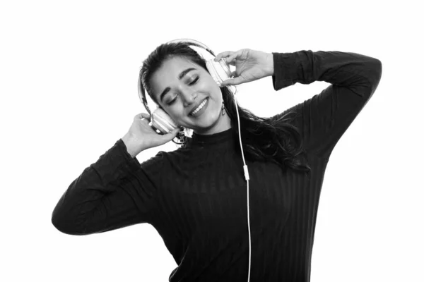 Fiatal boldog indiai nő mosolyog, miközben csukott szemmel zenét hallgat. — Stock Fotó