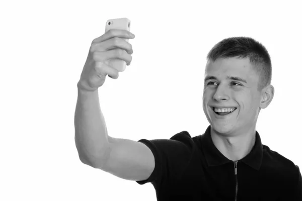 Jeune homme heureux caucasien souriant et prenant selfie avec téléphone mobile — Photo