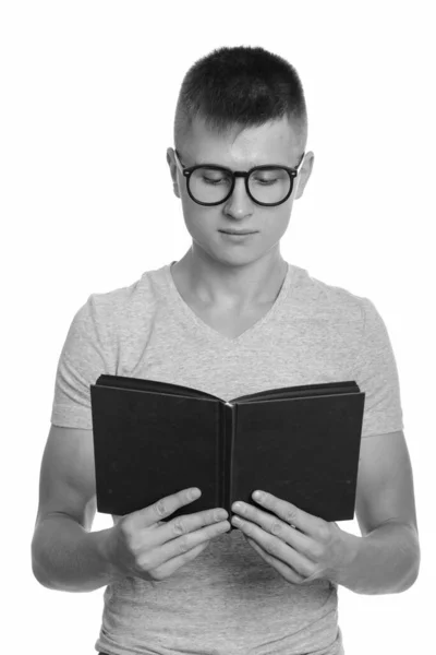 Retrato de un joven y guapo empollón leyendo libro con anteojos —  Fotos de Stock