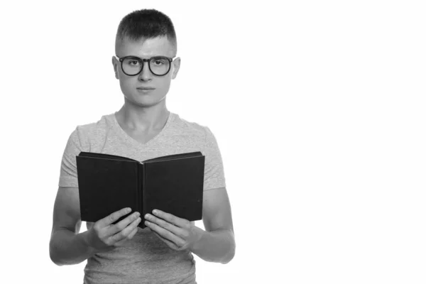 Ritratto di giovane bel nerd che legge un libro con gli occhiali — Foto Stock