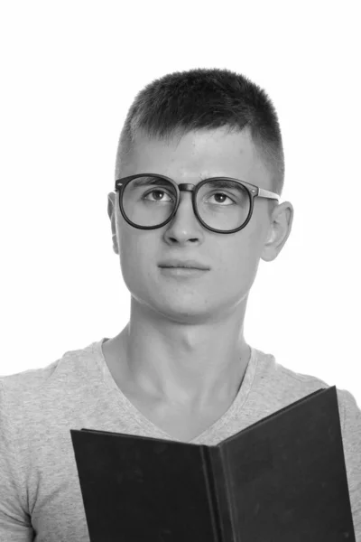 Joven hombre caucásico sosteniendo libro mientras piensa —  Fotos de Stock