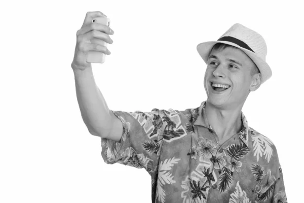 Joven hombre caucásico feliz sonriendo y tomando selfie con teléfono móvil —  Fotos de Stock