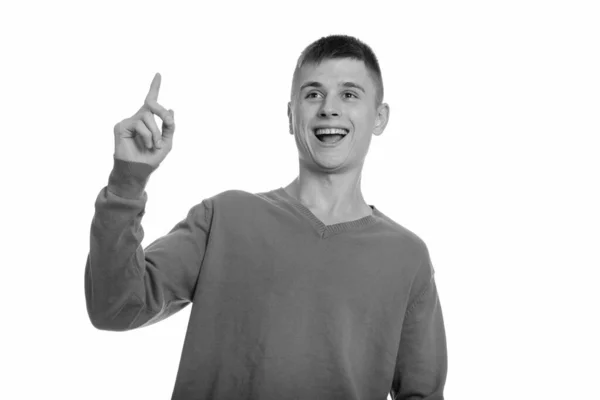 Pensativo joven feliz hombre caucásico sonriendo y señalando con el dedo hacia arriba — Foto de Stock