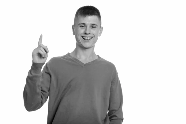 Joven feliz hombre caucásico sonriendo y señalando con el dedo hacia arriba —  Fotos de Stock