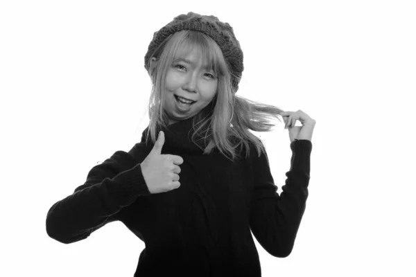 Joven mujer asiática feliz sonriendo y dando el pulgar hacia arriba mientras juega con su pelo —  Fotos de Stock