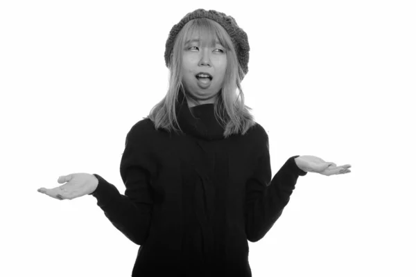 Portrait of young Asian woman with turtleneck sweater looking confused — Stock Photo, Image