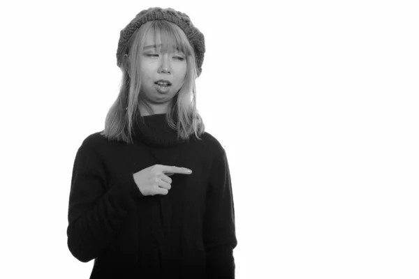 Joven linda mujer asiática mirando molesto y señalando el dedo a un lado —  Fotos de Stock