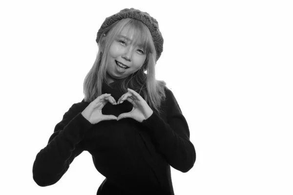 Joven feliz mujer asiática sonriendo y haciendo la mano signo del corazón —  Fotos de Stock
