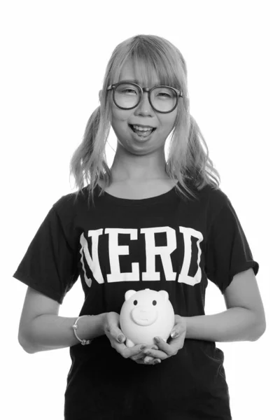 Jong gelukkig aziatisch nerd vrouw glimlachen en holding spaarvarken bank — Stockfoto