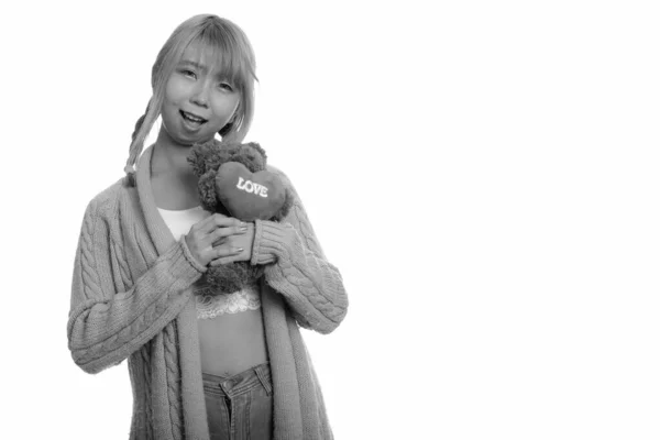 Fiatal boldog ázsiai nő mosolyog, és a kezében teddy mackó a szív és a szeretet jele — Stock Fotó
