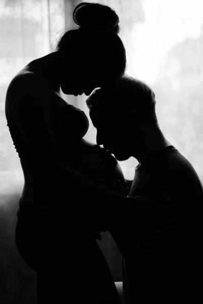 Multi ethnic couple married and in love in silhouette by the window — Stock Photo, Image