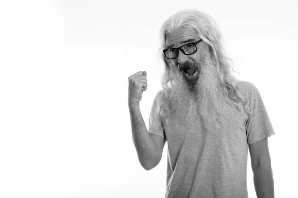 Estudio de tiro de hombre barbudo alto feliz sonriendo mientras se ve motivado y con gafas graduadas — Foto de Stock