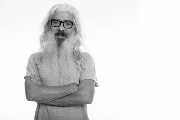 Studio shot of happy senior barbu homme souriant tout en portant des lunettes avec les bras croisés — Photo