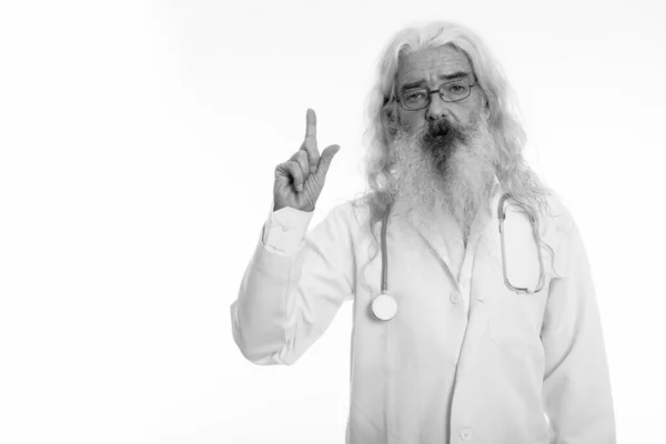 Студійний знімок старшого бородатого лікаря, який вказує пальцем вгору — стокове фото