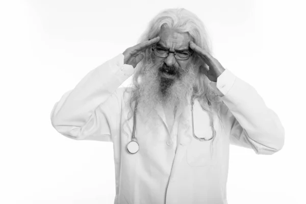 양손을 머리에 얹고 두 통을 겪고 있는 노인 의사가 스트레스를 받는 스튜디오 촬영 — 스톡 사진