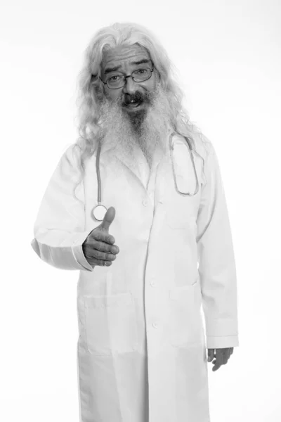 Студийный снимок счастливого бородатого мужчины-врача, улыбающегося и стоящего, пожимая руку — стоковое фото
