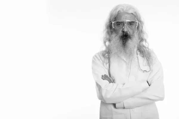Studio shot di anziano barbuto uomo medico indossa occhiali protettivi con le braccia incrociate — Foto Stock
