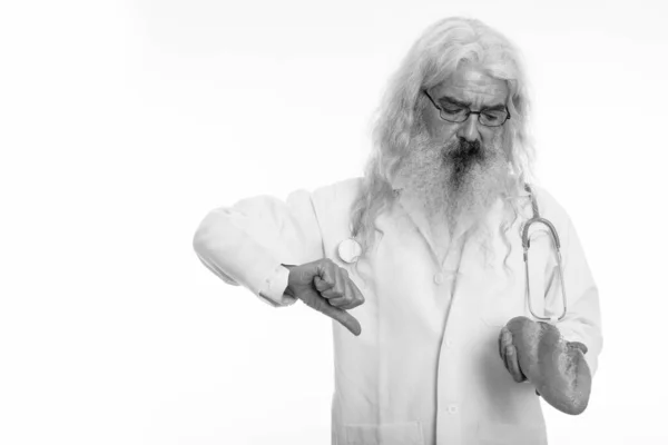Studio colpo di anziano barbuto uomo medico indossare occhiali mentre guardando il pane e dando pollice verso il basso — Foto Stock