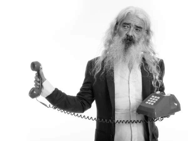 Studio shot van senior bebaarde zakenman met oude telefoon, terwijl op zoek geïrriteerd — Stockfoto