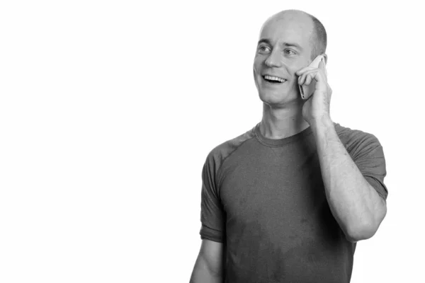 Ajattelevainen onnellinen kalju valkoihoinen mies hymyilee ja puhuu matkapuhelimella — kuvapankkivalokuva