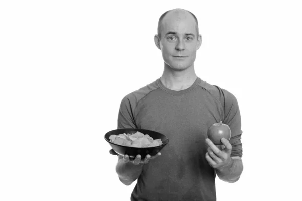 Καραφλός Καυκάσιος άντρας που κρατάει μπολ με πατατάκια και μήλο — Φωτογραφία Αρχείου