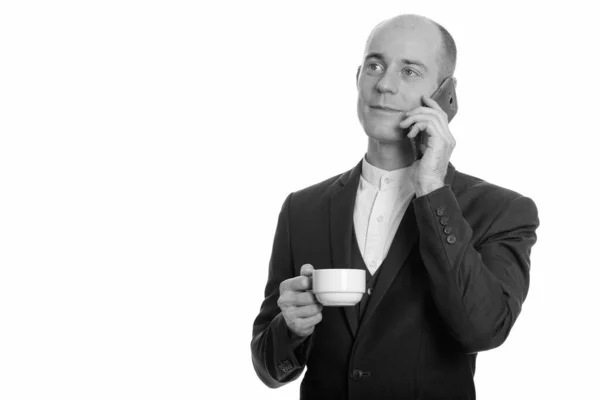 Pensativo feliz homem de negócios caucasiano careca sorrindo e falando no telefone celular enquanto segurando xícara de café — Fotografia de Stock