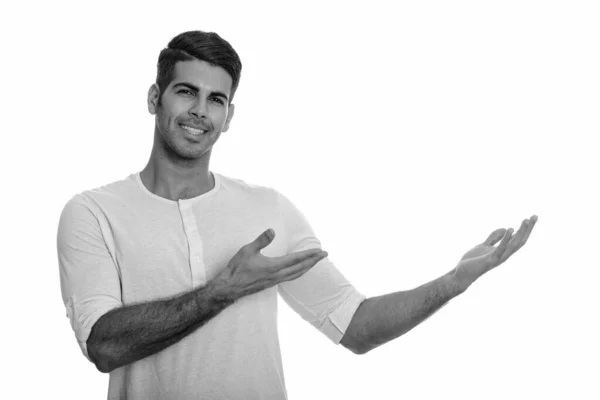 Joven hombre persa feliz sonriendo y mostrando algo — Foto de Stock