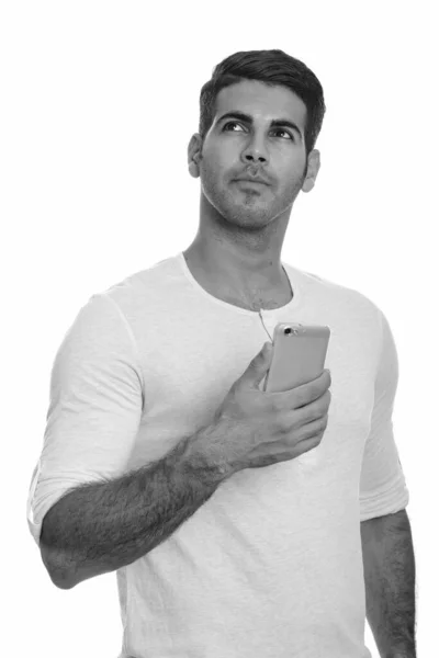 Jeune bel homme persan tenant un téléphone portable tout en pensant — Photo