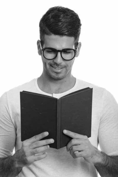 Jong gelukkig Perzische man glimlachend tijdens het lezen boek — Stockfoto