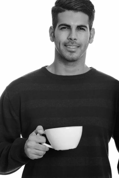 Jong gelukkig Perzische man glimlachend en met koffiebeker — Stockfoto