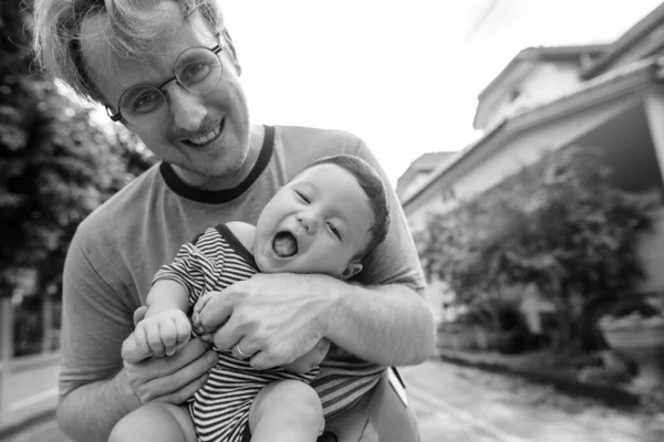 屋外の自宅で父と赤ちゃんの息子の絆 — ストック写真