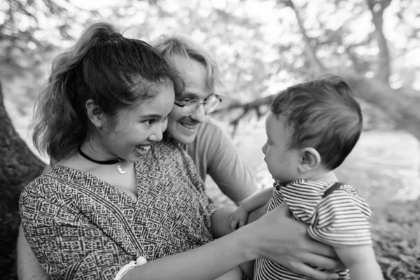 Multi ethnic young family bonding together at the park — Stock Photo, Image