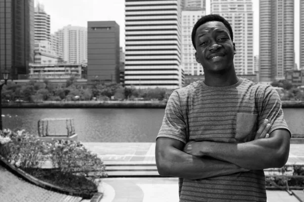 Jovem e bonito homem africano relaxando no parque — Fotografia de Stock