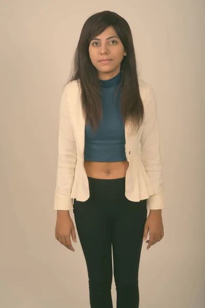 Studio shot of young Persian businesswoman standing against gray background — Stock Photo, Image