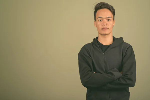 Joven hombre indio guapo con sudadera con capucha sobre fondo de color —  Fotos de Stock