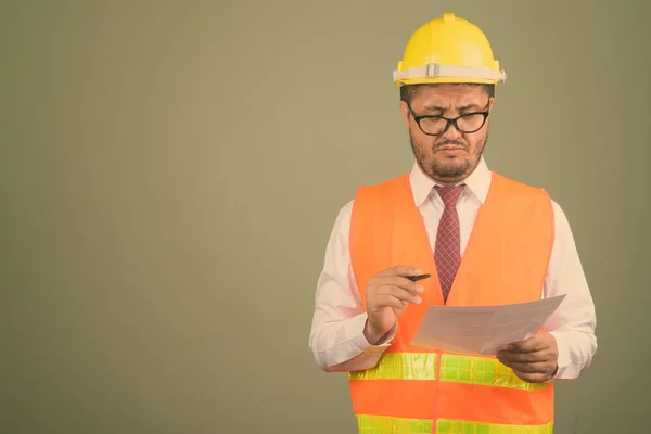 Barbudo hombre persa trabajador de la construcción contra el fondo de color —  Fotos de Stock