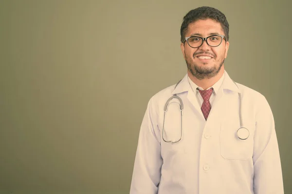 Homem barbudo persa médico contra fundo colorido — Fotografia de Stock